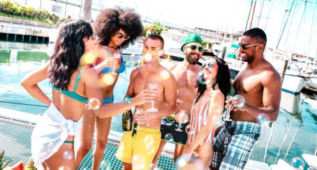 Młoda różnorodna grupa ludzi dobrze się bawi pijąc wino na imprezie żaglówki - Koncepcja przyjaźni z szczęśliwymi przyjaciółmi wielorasowymi na żaglówce - Szczęśliwy styl życia w podróży w luksusowej lokalizacji VIP - Jasny filtr